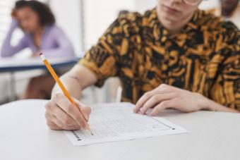 Student filling out a bubble answer sheet with a pencil during a Credit by Examination test