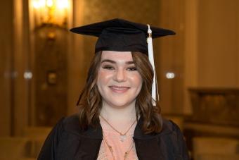 A UT High School Class of 2015 graduate pauses for a photo in the ceremony hall